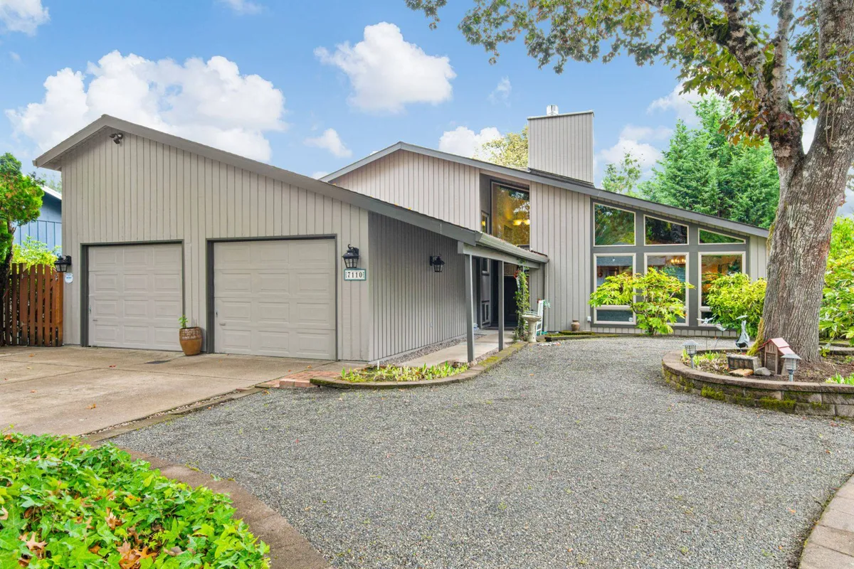 An exterior shot showcasing modern architecture, large windows, and a landscaped garden. The scene conveys a secure and welcoming environment with ample space for parking and a tranquil neighborhood backdrop.